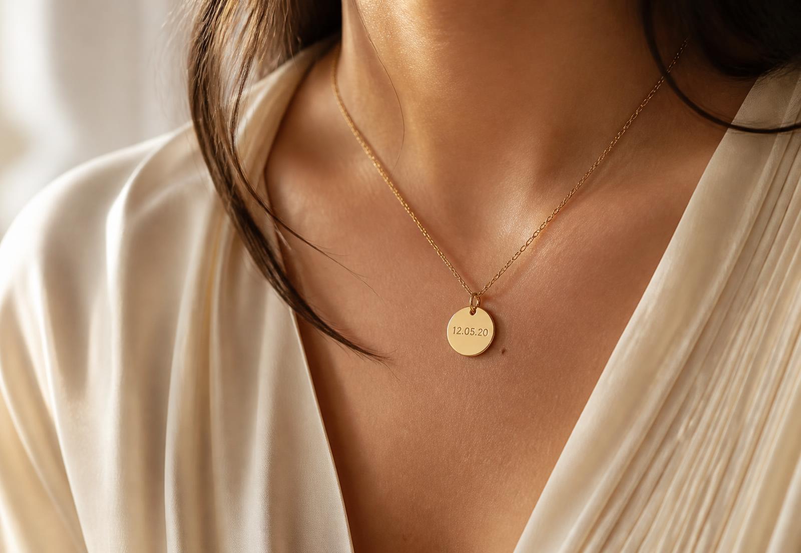 Woman wearing a delicate gold personalized pendant necklace engraved with a date